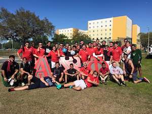 A group of college students poses on a soccer field on campus